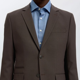 Model wearing Selected Neil Slim Single-Breasted Suit Jacket in Delicioso brown, notch lapel, two-button fastening, styled with blue shirt