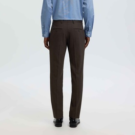 Model wearing Selected Neil Slim Suit Trousers in Delicioso brown, rear view showing ironed crease and back pockets, styled with blue shirt and black