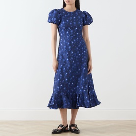 Model wearing Sister Jane navy floral jacquard midi dress with puff sleeves and frill hem, styled with black mule loafers