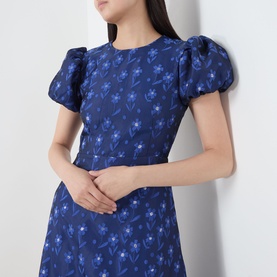 Model wearing Sister Jane navy floral jacquard dress with puff sleeves and crew neck, cropped close-up view.