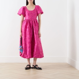 Model wearing Sister Jane pink jacquard midi dress with puff sleeves, styled with black Mary Jane flats and a small multicolour bag.