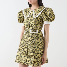 Model wearing Sister Jane olive floral mini dress with white oversized collar, puff sleeves, contrast cuffs and matching belt detail.