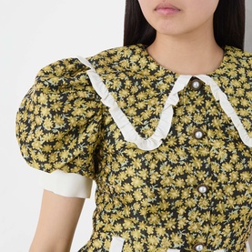 Model wearing Sister Jane olive floral dress with puff sleeves, white lace-trim collar and pearl button detail