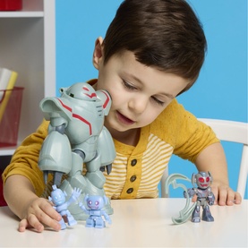 Model with Superheroes multicoloured action figure playset; child plays with large robot and small hero figures on white table.