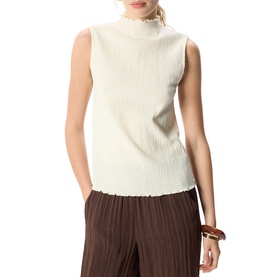 Model wearing Whistles cream sleeveless ribbed high-neck top, styled with brown wide-leg pleated trousers.