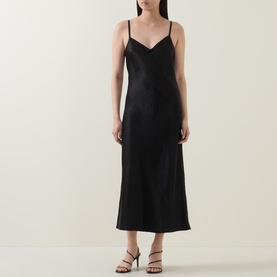 Model wearing Vince Satin Slip Dress in black, V-neckline, slim straps, midi length, styled with black strappy heeled sandals.