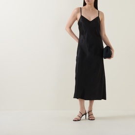 Model wearing Vince Satin Slip Dress in black, midi length, V-neckline, slim straps, styled with strappy heels and a black clutch.