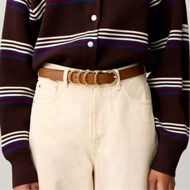 Model wearing Claude Pierlot brown leather belt with gold chain ring detail, styled with cream jeans and striped dark brown cardigan.