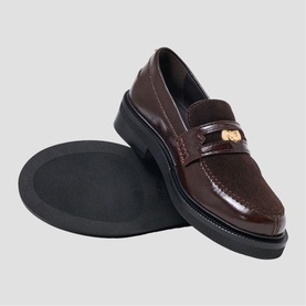 Maje dark brown patent leather loafers with gold-tone hardware detail, chunky black sole, shown as a pair from above angle