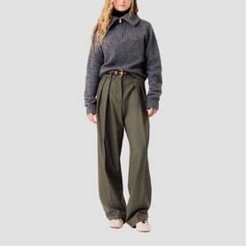 Model wearing Maje grey half-zip knit sweater and olive wide-leg trousers with tan belt, styled with cream trainers