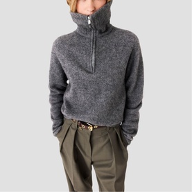 Model wearing Maje red high-neck half-zip fleece pullover, styled with khaki tailored trousers and embellished belt.