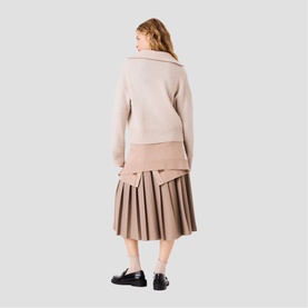 Model wearing Maje cream zip-neck sweatshirt, styled with taupe pleated midi skirt and black loafers, back view