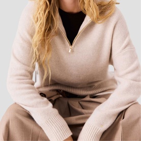 Model wearing Maje clear half-zip knit jumper with ribbed cuffs, styled with black top and taupe wide-leg trousers