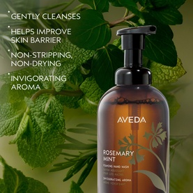 Aveda Rosemary Mint Invigorating Foaming Hand Wash in amber pump bottle, surrounded by fresh mint leaves