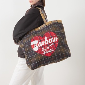 Model carrying Barbour Heart Logo Graphic Tartan Tote Bag in multi tartan, red heart logo print, canvas finish, shoulder straps visible