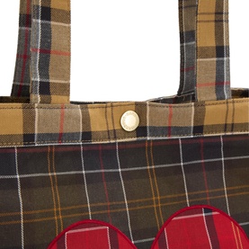 Barbour multi tartan cotton tote bag close-up showing gold snap button, woven handles, and red bow detail at base.