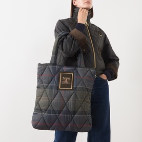 Model carrying Barbour Arlene Logo Tartan Tote Bag in multi, quilted finish with logo badge, styled with tartan jacket and jeans