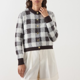 Model wearing Barbour International multi check cardigan with gold buttons, styled with white wide-leg trousers