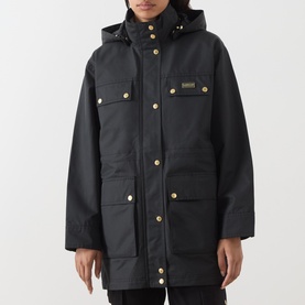 Model wearing Barbour International Molina Showerproof Coat in black with gold snap buttons, detachable hood, chest flap pockets and longline
