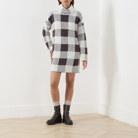 Model wearing Barbour International multi check knit mini dress with ribbed turtleneck, styled with ankle socks and black chunky boots.