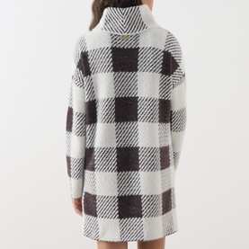 Model wearing Barbour International dress in monochrome buffalo check, rear view, oversized fit with roll neck and long sleeves.