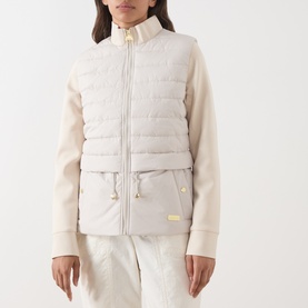 Model wearing Barbour International Ari Hybrid Quilted Jacket in Moonbeam, with padded bodice, contrast sweatshirt sleeves and gold-toned hardware.