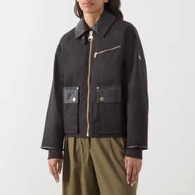 Model wearing Barbour International dark brown cotton jacket with leather-trim collar, gold-tone zip and hardware, large front pockets, styled with