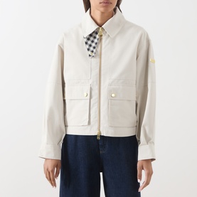 Model wearing Barbour International moonbeam jacket with gold-tone zip and snap buttons, styled with gingham shirt and dark jeans