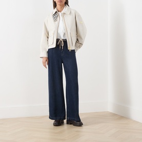 Model wearing Barbour International Moonbeam jacket with wide-leg dark navy jeans and black loafers