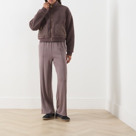 Model wearing Barbour International Truffle zip-up fleece jacket with patch pockets, styled with wide-leg trousers