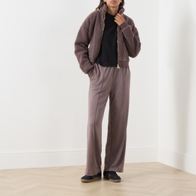Model wearing Barbour International Truffle jacket with matching wide-leg trousers, styled with a black top and dark trainers.