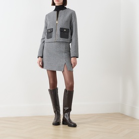 Model wearing Barbour International Halina Gingham Zip Jacket in multi, styled with matching mini skirt and dark brown knee-high boots.
