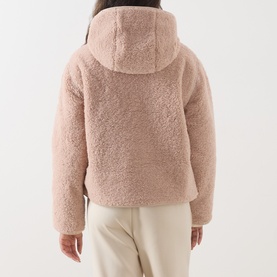 Model wearing Barbour International Ramona Zip-Up Fleece Jacket in Nutmeg, rear view showing fixed hood and sherpa texture, styled with cream trousers