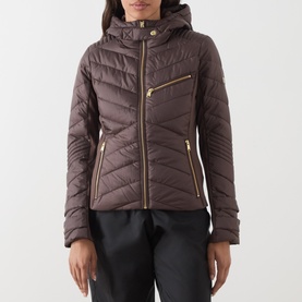 Model wearing Barbour International truffle quilted hooded jacket with gold-tone zip detailing, styled with black trousers.