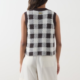 Model wearing Barbour International multi check knit vest, back view, styled with white wide-leg trousers