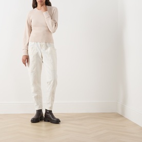 Model wearing Barbour International Cyrus Dropped-Shoulder Sweater in Nutmeg with white cargo trousers and black Chelsea boots