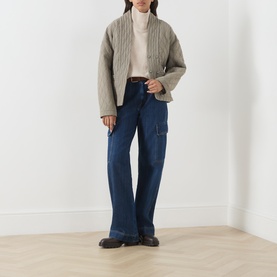 Model wearing Barbour International Moonbeam knitwear turtleneck, styled with quilted jacket, dark blue cargo jeans and brown loafers.