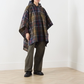 Model wearing Barbour multi check poncho with hood, styled with olive wide-leg trousers and black chunky loafers