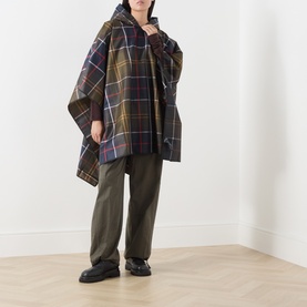 Model wearing Barbour multi tartan check poncho, styled with khaki wide-leg trousers and black chunky loafers