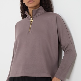 Model wearing Barbour International Kemora Logo Half-Zip Sweatshirt in Truffle with gold-toned zip and long sleeves