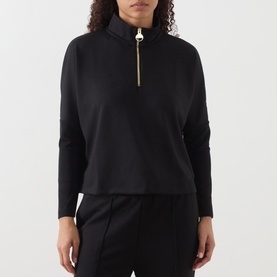 Model wearing Barbour International Kemora Logo Half-Zip Sweatshirt in black with gold-toned zip, styled with black trousers.