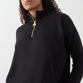 Model wearing Barbour International Kemora Logo Half-Zip Sweatshirt in black with gold-toned zip detail at funnel neck.