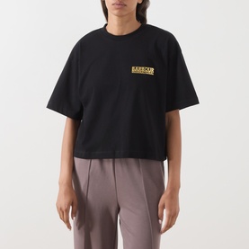 Model wearing Barbour International black cotton T-shirt with yellow logo print on chest, styled with grey trousers.