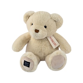 Dou Dou cream plush teddy bear with soft fur, brown nose, and branded label on foot, seated upright