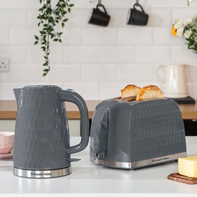 Russell Hobbs Honeycomb 2 Slice Toaster Grey with matching grey kettle on a kitchen counter, both with silver bases
