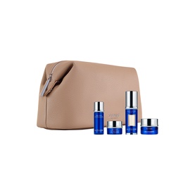 La Mer skincare gift set with five blue products including serum, moisturiser and eye cream, presented in a beige cosmetics pouch
