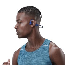 Model with Shokz OpenMove Wireless Headphones in blue, bone conduction style, worn by a runner in a blue vest