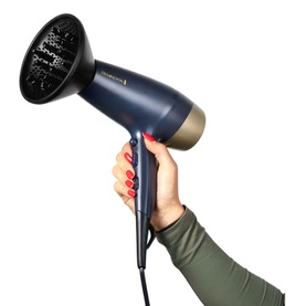 Remington Sapphire Luxe Hair Dryer in Deep Navy and Champagne with diffuser attachment, held by a hand with red nails.