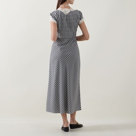 Model wearing Rixo Beth Check Black dress, back view, black and white gingham print, lace collar detail, midi length, black flats.