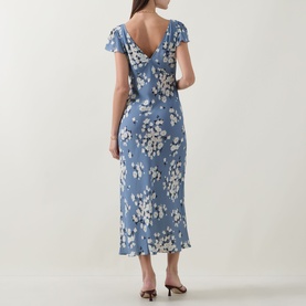 Model wearing Rixo Cathy Floral Dress in Amelia Bouquet Blue, showing V-back neckline, short sleeves, and midi-length bias cut silhouette.